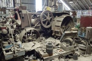 Övergiven industrilokal fylld med dammiga, gamla maskindelar och utrustning.